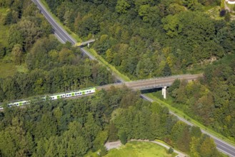 Aerial view, suburban railway crossing a bridge and adjacent pedestrian bridge over the
