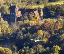 Aerial photo, motor glider at Heessen Castle in the autumnal forest in the Heessen district of
