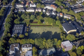 Aerial view, indoor swimming pool and sports hall as well as youths on the sports field at the
