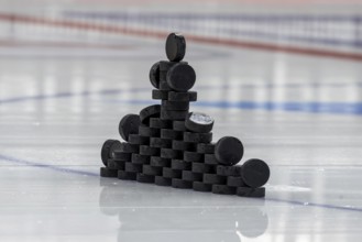 Ice hockey symbol image: Close-up of pucks stacked on the ice for the warm-up game
