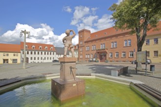 Market fountain with juice boy, symbol of historical drinking water supply, boy drinking, town