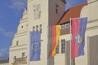 Renaissance town hall with EU flag, German national flag and town flag, three, flags, sundial, wall