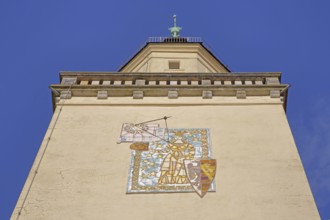 Tower with town coat of arms and sundial, wall mosaic, figure with shield and crown, view upwards,