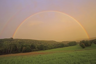 Half-round rainbow with forest and fields, landscape, light mood, nature photography,