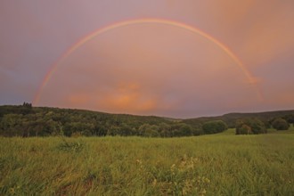 Half-round rainbow with forest and fields, landscape, light mood, nature photography,