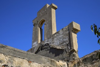 Tower-like structure with crumbling façade in front of a clear blue sky, Old Silk Factory, German