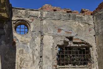 Old walls with round and rectangular lattice window, surrounded by bricks, Old silk factory,