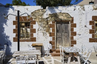 Taverna, Rustic wall with wooden doors, lights and weatherboarded brickwork, Kattavia village,