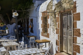 Taverna, A rustic café with wooden furniture and old walls in the shade of a tree, Kattavia