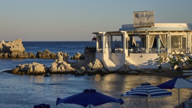 Restaurant Argo, Cosy restaurant by the sea with rocks in the water and evening sun, protected by
