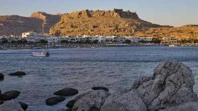 Feraklos fortress, coastal town with a castle above the evening sky and rocks on the shore, bay,