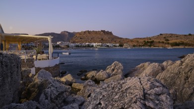 Restaurant Argo, Rock-framed view of a coastal town and sea at dusk, bay, Feraklos fortress,
