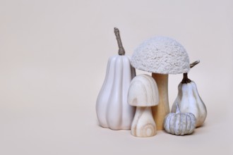 Decorative mushroom and pumpkin ornaments on beige background with copy space. Autumn seasonal