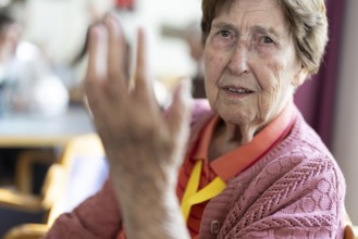 Over 90-year-old senior citizen with dementia talks and gesticulates with her wrinkled hands in a