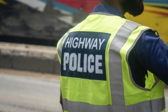 Back view of a highway police officer wearing a reflective vest, Dhaka, Bangladesh