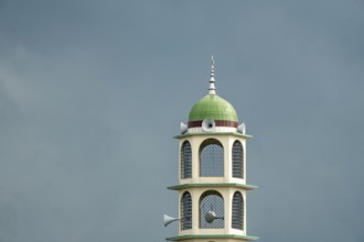 A tower with a dome and speakers against an overcast sky, Dhaka, Bangladesh