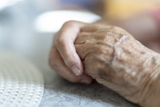 Wrinkled hands of a 90+ year old senior citizen lying on the table in a retirement home, Cologne,