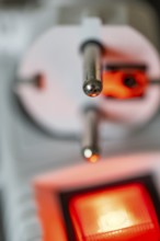 Close-up of a white power plug, Schuko plug, on a multiple socket with red indicator light,