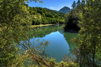 Ibiur reservoir is reflecting the surrounding lush vegetation and blue sky on a beautiful sunny day