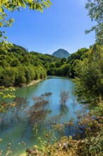 Ibiur reservoir reflecting vibrant trees and a majestic mountain adorned with lush vegetation on a