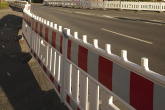 Borken, NRW, Germany, Red and white traffic barriers lining a paved road, guiding traffic flow and