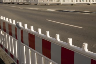 Borken, NRW, Germany, Red and white striped plastic construction barrier closing an empty asphalt