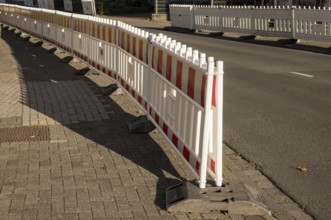 Borken, NRW, Germany, Red and white plastic road barriers creating a division between sidewalk and