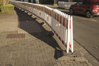 Borken, NRW, Germany, Red and white plastic construction barriers lining a paved walkway beside a