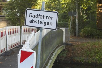 Borken, NRW, Germany, Cyclists dismount sign and construction barriers blocking access to a small