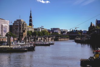 A busy harbour with many boats, a bridge and urban architecture under a clear sky. View from the