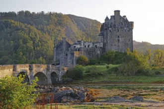 Historic castle on an inlet with dramatic mountains in the background, Eilean Donan Castle,