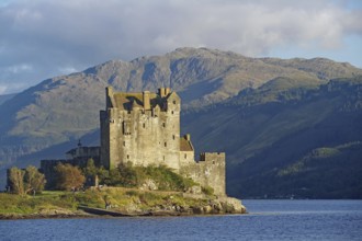 Historic castle on an inlet with dramatic mountains in the background, Eilean Donan Castle,