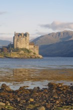 Historic castle on an inlet with dramatic mountains in the background, Eilean Donan Castle,