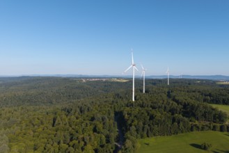 Three wind turbines rise above lush forest and green countryside, near Schorndorf, Rems Valley,