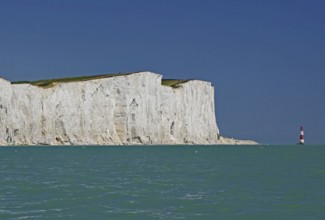 White cliffs on turquoise sea with view of red lighthouse, Old Harrys Rock, Beachy Head Lighthouse,