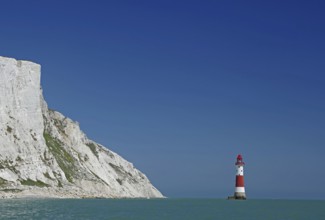 Red lighthouse in front of white cliffs at the blue sea, Old Harrys Rock, Beachy Head Lighthouse,