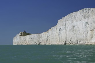 White cliffs with a small lighthouse by the turquoise sea, Old Harrys Rock, Bournemouth, Dorset,