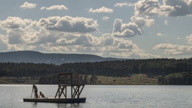 Children playing on a platform at a bathing place at Lake Mjøsa or Mjosa with wooded shore,