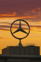 Large Mercedes-Benz logo in front of a dramatic sunset, Stuttgart, Baden-Württembwerg, Germany
