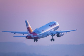 Eurowings aircraft flying in a pink coloured evening sky, Stuttgart, Baden-Württembwerg, Germany