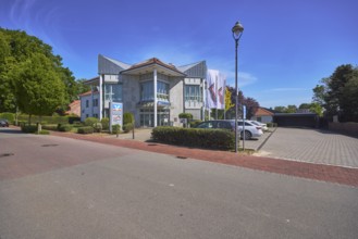 Vereinigte Volksbank eG - Branch Alfhausen, modern architecture, lantern, car park with vehicles,