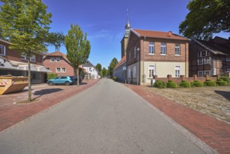 Street, church tower of St. Johannis, brick building, trees, blue sky, cirrostratus clouds, main