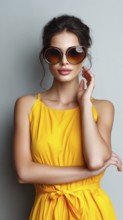 Fashion beautiful lady poses in fashionable modern clothes on yellow background. Model poses
