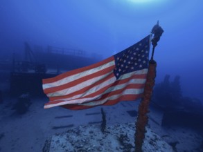 USA flag on a wreck under water, surrounded by deep blue. Dive site Wreck of the USS Spiegel Grove,