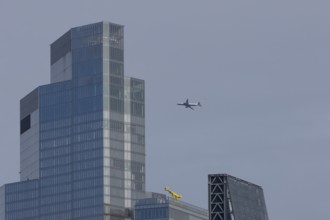 Jet passenger aircraft of British Airways airlines in flight in a blue sky with a city office block