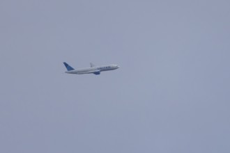 Jet passenger aircraft of United Airlines flying in a blue sky, England, United Kingdom