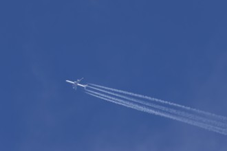 Airbus A340-300 jet aircraft of Lufthansa airlines in flight in a blue sky with vapour trails or