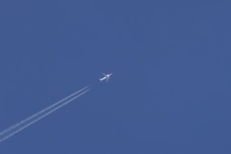 Boeing 737 jet passenger aircraft of Norweign Air with a vapour trial or contrail behind flying in