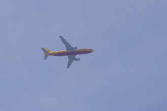 Boeing 767 jet aircraft of DHL cargo airlines in flight in a blue sky, England, United Kingdom