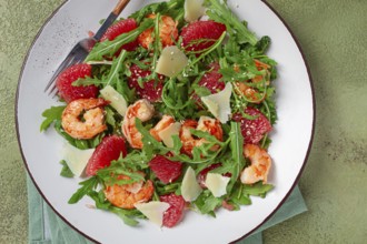 Fresh shrimp salad with arugula, grapefruit, and parmesan served in a bowl